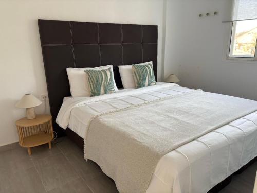 ベラにあるNaturist Paradise by the Beachのベッドルームに大型ベッド1台(大型ヘッドボード付)