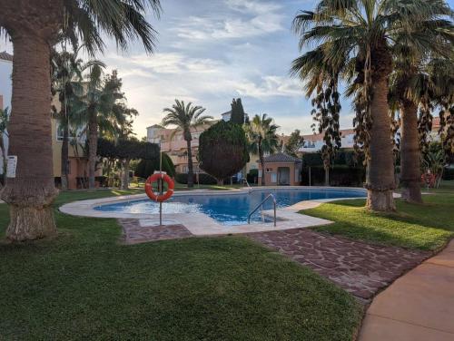 ベラにあるNaturist Paradise by the Beachのヤシの木が茂る公園内のスイミングプール