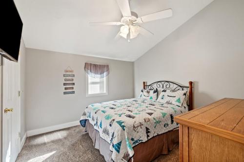 a bedroom with a bed and a ceiling fan at Little blue house on the lake in Nancy