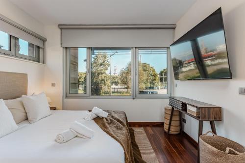 une chambre avec un grand lit blanc et des fenêtres dans l'établissement Beachside apartment, à Sant Adrià de Besòs