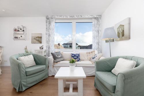 ein Wohnzimmer mit zwei Stühlen und einer Couch und einem Tisch in der Unterkunft Dorfring 36 Albatros in Stein