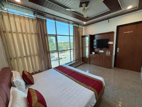 Un dormitorio con una cama grande y una ventana grande. en Hotel Shivaay, en Jodhpur