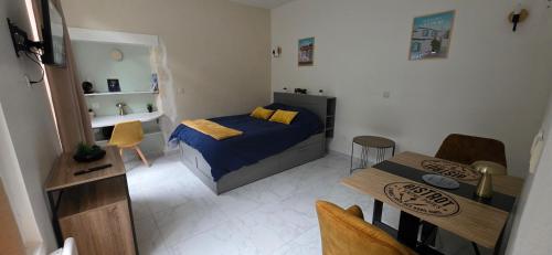 une petite chambre avec un lit et une table dans l'établissement Studio Cosy entièrement rénové - Centre Historique, à Rochefort