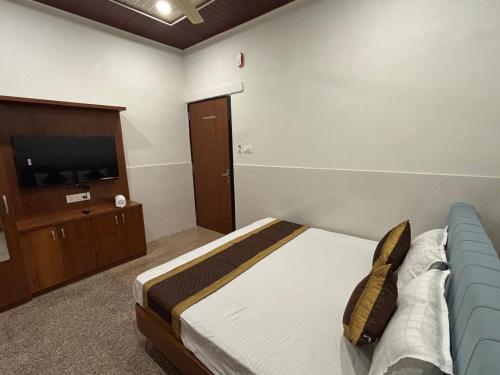 Un dormitorio con una cama y un televisor de pantalla plana. en Hotel Shivaay, en Jodhpur