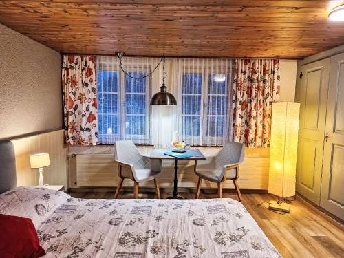 een slaapkamer met een bed, een tafel en stoelen bij Apartment Chalet Auf dem Vogelstein-1 by Interhome in Grindelwald