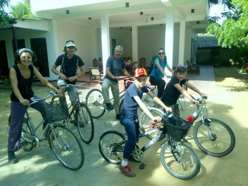 a group of people posing with their bikes at Jayaru Guest House in Polonnaruwa