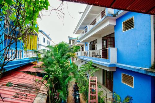 Una vista de un edificio azul con palmeras. en Hotel Sky Blue Baga Goa, en Baga