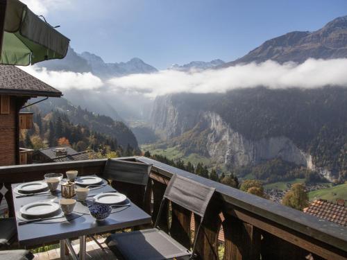 a table on a balcony with a view of the mountains at Apartment Drei Tannen by Interhome in Wengen