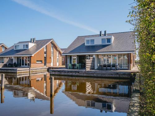 eine Reihe von Häusern neben einem Fluss in der Unterkunft Holiday Home Busch en Dam by Interhome in Uitgeest