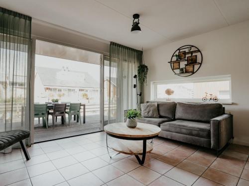 a living room with a couch and a table at Holiday Home Busch en Dam by Interhome in Uitgeest