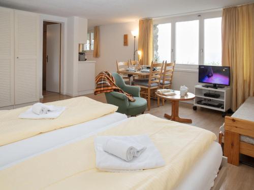 a hotel room with two beds and a living room at Studio Helene Studio Christel by Interhome in Wengen