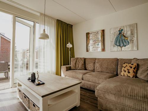 a living room with a couch and a table at Holiday Home Assum by Interhome in Uitgeest