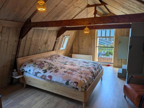 une chambre avec un lit dans une pièce aux murs en bois dans l'établissement De oude walnoot, à Sint Pancras