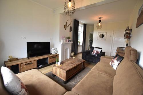 a living room with a couch and a coffee table at The Holidayhouse - 5 min Efteling - max 5 pers & 1 baby in Loon op Zand