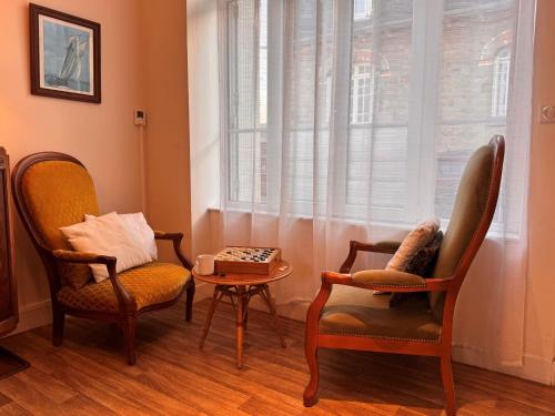 a living room with two chairs and a table and a window at Holiday Home Bel Air by Interhome in Cancale