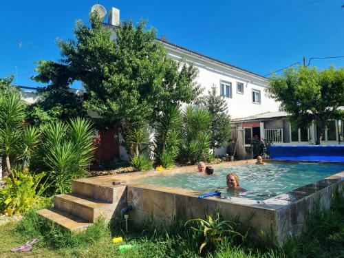 a group of people in a swimming pool in a yard at Yuccasa - Small Glamping Camping & Studio's in Pombal