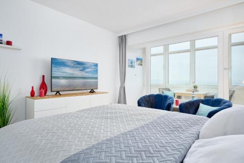a bedroom with a bed and a tv on a wall at Strandbude in Laboe