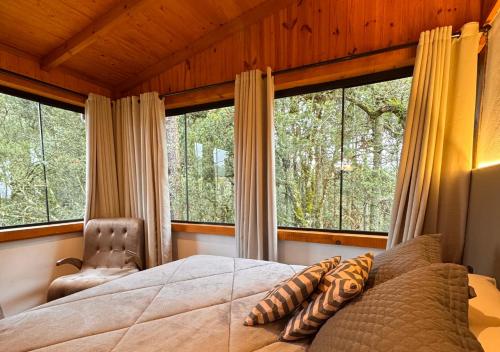 a bedroom with a bed and two large windows at Fazenda Santa Rita Turismo Rural in Bom Jardim da Serra