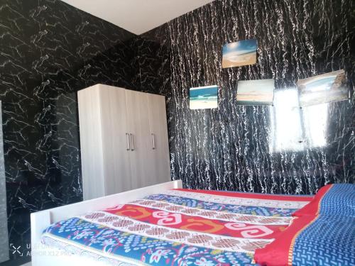 a bedroom with a bed and a black wall at Apart-Hotel Ca Elsa in Sal Rei