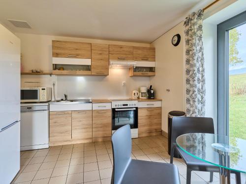 eine Küche mit Tisch und Stühlen und einem Fenster in der Unterkunft Holiday Home Holiday Hill 58 by Interhome in Lauterwasser