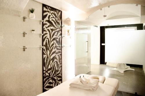 une salle de bain avec un canapé blanc et une douche dans l'établissement Hôtel Roi de Sicile - Rivoli, à Paris