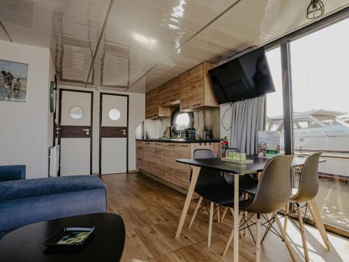 a living room and kitchen with a table and chairs at Holiday Home Campi 400 by Interhome in Uitgeest