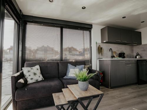 a living room with a couch and a table at Holiday Home Havenlodge by Interhome in Uitgeest