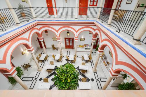 Una vista aérea de un vestíbulo con mesas y sillas. en Sercotel Las Casas de los Mercaderes, en Sevilla