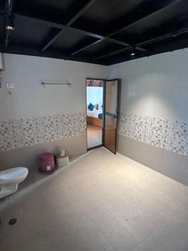 an empty room with a toilet and a doorway at A1 Tiger Resort in Kolāra