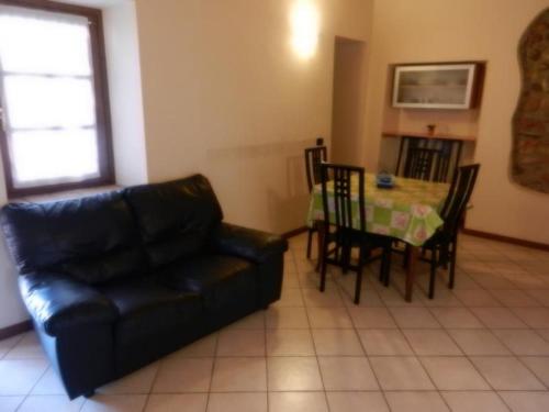 un salon avec un canapé en cuir noir et une table dans l'établissement Appartasmento Ficus, à bedizzol