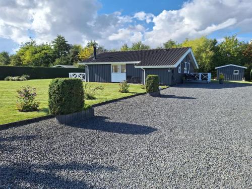 ein Haus mit einer Kiesauffahrt davor in der Unterkunft Holiday Home Gustava - 700m from the sea by Interhome in Neder Lysabild