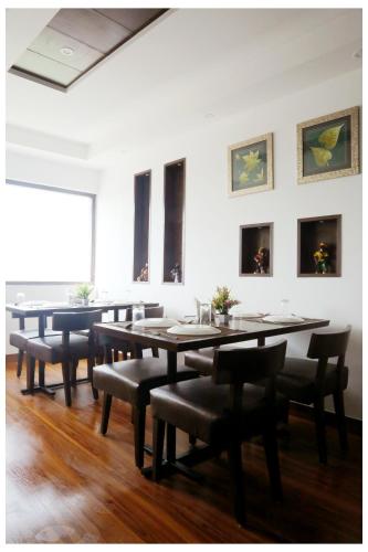 a dining room with tables and chairs and paintings on the wall at Airport Hotel The R Blues - New Delhi in New Delhi