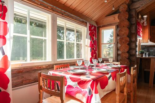 a dining room table with a red and white table cloth at Villa Talvikolo - Spacious 2BR Cabin with Sauna in Ruka