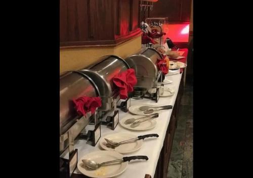 Una línea de buffet con platos y utensilios en Meadowlands Plaza Hotel, en Secaucus