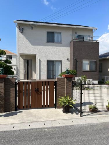 a house with a wooden gate and a fence at 心愈庭 in Itoman
