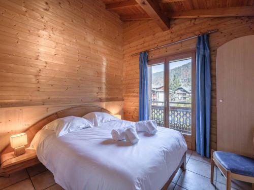 a bed in a wooden room with a window at Appartement 4 pièces à Morzine, skis aux pieds, jacuzzi, 9 pers, 100m², centre, animaux admis - FR-1-754-24 in Morzine