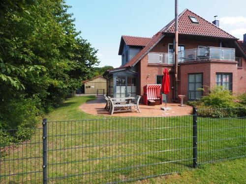 a house with a fence in front of it at Ferienhaus Seegang Mit Eingezäuntem Grundstück in Flessenow