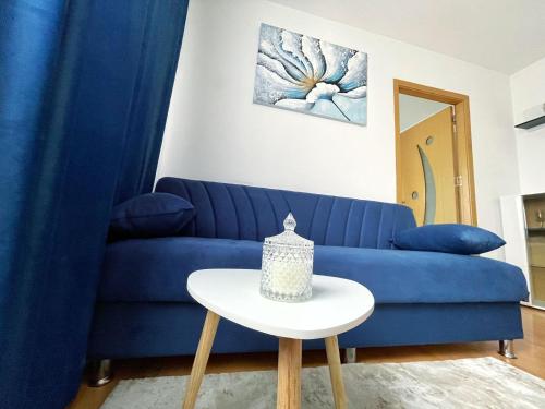 a blue couch in a living room with a table at BDR Residence in Craiova