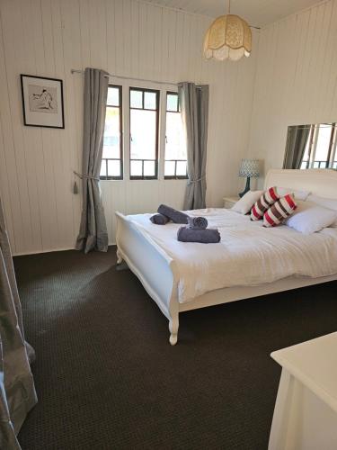 a bedroom with a large bed with pillows on it at Main St Heritage Charm & Walk to Restaurants in Mount Tamborine