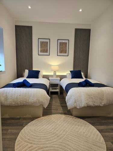 a bedroom with two beds with blue pillows at Spacious 3-Bedroom Apartment with Private Parking & Wi-Fi in Hull