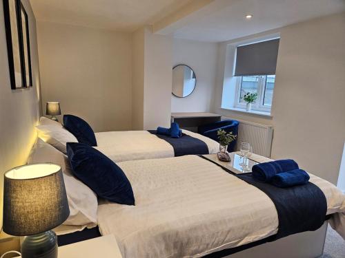 a hotel room with two beds with blue pillows at Spacious 3-Bedroom Apartment with Private Parking & Wi-Fi in Hull