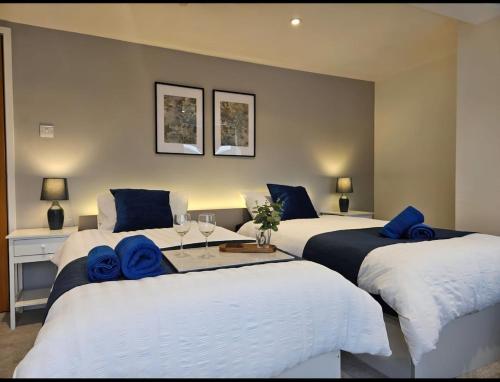 a bedroom with three beds with blue towels on them at Spacious 3-Bedroom Apartment with Private Parking & Wi-Fi in Hull