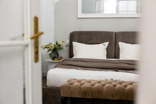 a bedroom with a bed with a brown headboard and white pillows at Romari Братів Рогатинців 32 in Lviv
