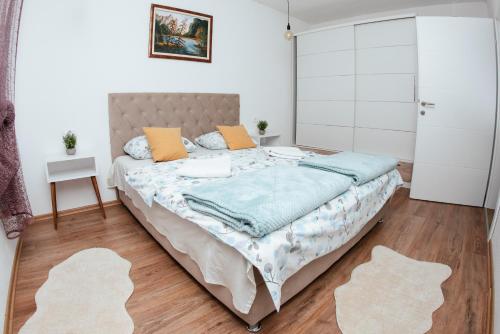 a bedroom with a large bed with blue sheets and orange pillows at Villa Lotta & Nolla in Mostar