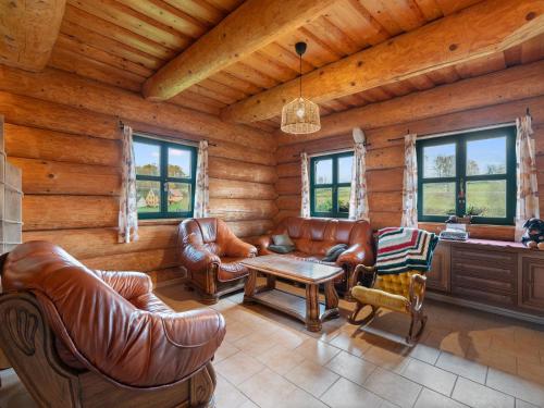 a living room with leather furniture in a log cabin at Chalet Srub Pohodář by Interhome in Benešov nad Černou