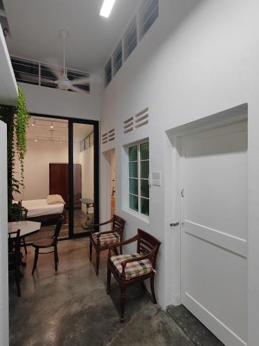 a living room with chairs and a table and a bed at Zen 1 Room KL in Kuala Lumpur