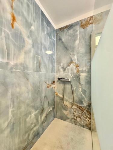 a bathroom with a shower with marble tiles at Villa Heusenstamm in Heusenstamm