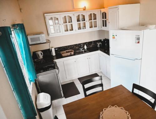 a small kitchen with a table and a refrigerator at Ocean Heights in Arnos Vale