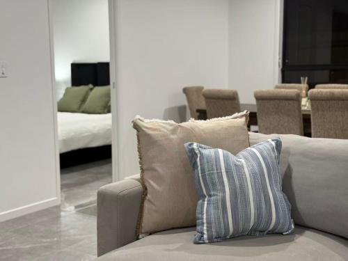 eine Couch mit einem Kissen in einem Wohnzimmer in der Unterkunft Sunnybank Station 5B Family Stay in Brisbane