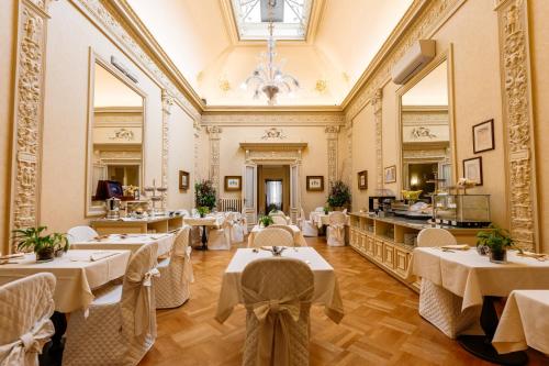 a restaurant with tables and chairs in a room at Hotel Posta in Reggio Emilia